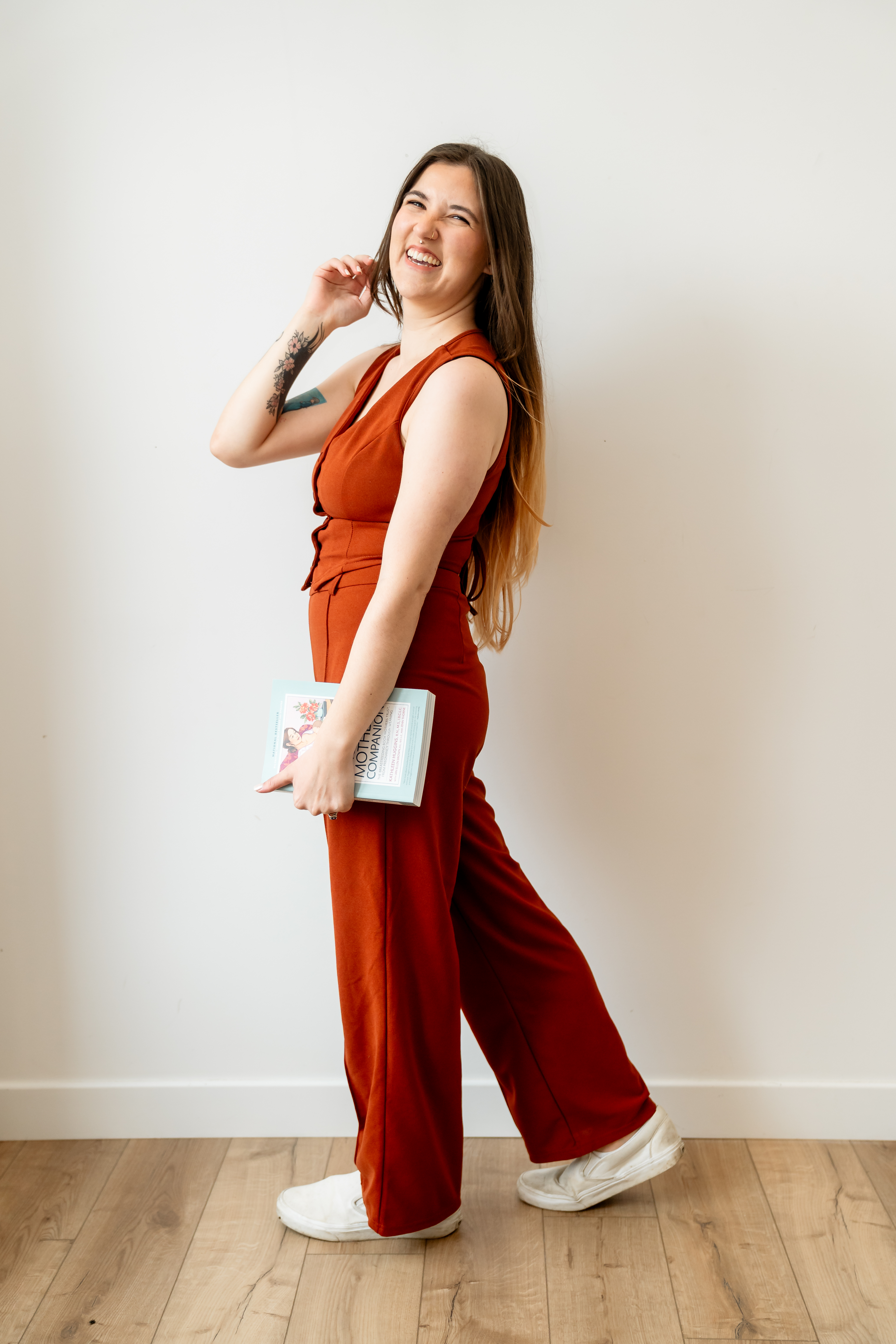 Doula, Amber, standing with a book in hand titled the nursing mother's companion